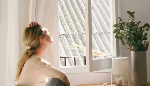 žena pored prozora sunce