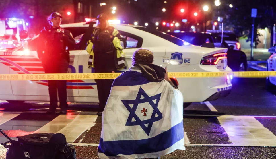 epaselect epa12124462 A man with an Israeli flag draped on his shoulders near the scene where two people were shot and killed near the Capital Jewish Museum in Washington, DC, USA, 22 May 2025. According to a social media post by the US Homeland Security Secretary Kristi L. Noem, the two people killed were staff members at the Israeli embassy. EPA/WILL OLIVER