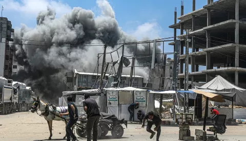 epa12127900 Palestinians try to take cover as smoke rises following an Israeli airstrike west of Gaza City, in Gaza Strip, 23 May 2025. More than 53,700 Palestinians have been killed in the Gaza Strip, according to the Palestinian Ministry of Health, since Israel launched a military campaign in the strip in response to a cross-border attack led by the Palestinian militant group Hamas on 07 October 2023, in which about 1,200 Israelis were killed and more than 250 taken hostage. EPA/MOHAMMED SABER