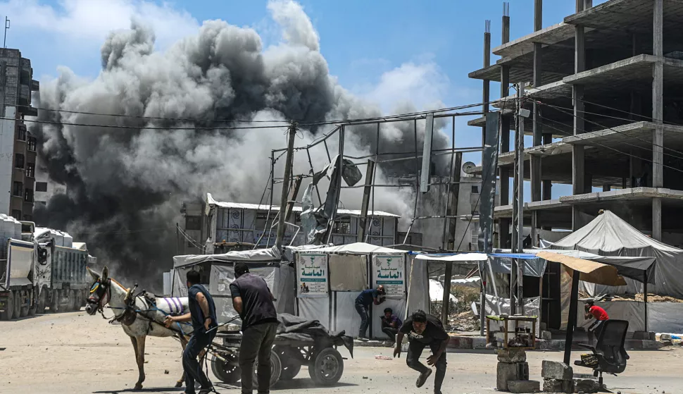 epa12127900 Palestinians try to take cover as smoke rises following an Israeli airstrike west of Gaza City, in Gaza Strip, 23 May 2025. More than 53,700 Palestinians have been killed in the Gaza Strip, according to the Palestinian Ministry of Health, since Israel launched a military campaign in the strip in response to a cross-border attack led by the Palestinian militant group Hamas on 07 October 2023, in which about 1,200 Israelis were killed and more than 250 taken hostage. EPA/MOHAMMED SABER