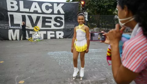 epa08476930 A mother photographs her daughter skating in front of a huge Black Lives Matter banner at Lafayette Park in Washington, DC, USA, 10 June 2020. Work crews have started to remove the fencing that was erected around the White House grounds and Lafayette Square during the protests over the death of George Floyd in police custody. EPA/SHAWN THEW