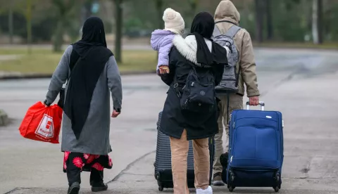 dpatop - 13 March 2025, Brandenburg, Eisenh?ttenstadt: Migrants leave the premises of Brandenburg's Central Immigration Office (ZABH) with luggage. Brandenburg is taking a new approach to speeding up the return of asylum seekers to Poland. A new so-called "Dublin Center" for the faster return of asylum seekers to other EU states is starting work. The aim is to speed up the organization of transfers to Poland. This involves so-called Dublin cases, i.e. people who have to go through their asylum procedure in another EU country. Photo: Patrick Pleul/dpa Photo: Patrick Pleul/DPA