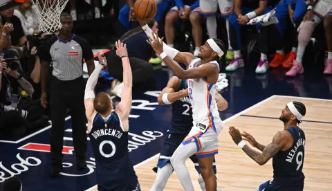 epa12138006 Oklahoma City Thunder guard Shai Gilgeous-Alexander (C) goes up for a shot past Minnesota Timberwolves guard Donte DiVincenzo (L) and guard Nickeil Alexander-Walker during the second half of game four of the Western Conference finals between the Oklahoma City Thunder and the Minnesota Timberwolves at the Target Center in Minneapolis, Minnesota, USA, 26 May 2025. Oklahoma City Thunder won 128-126. EPA/CRAIG LASSIG