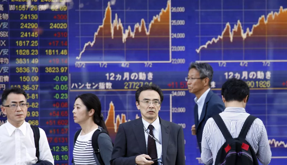 epa07053293 Pedestrians stand before a stock market indicator board in Tokyo, Japan, 28 September 2018. Tokyo's Nikkei index rose by more than 1.3 per cent thanks to a weaker yen and optimism with US trade. The Nikkei 225 index gained 323.30 points, or 1.36 per cent, to close at 24,120.04, after reaching a nearly 27-year high figure earlier in the day. EPA/FRANCK ROBICHON
