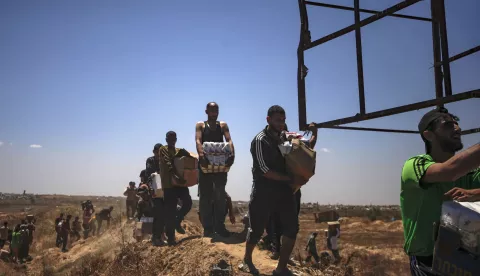 epa12143228 Palestinians carry aid supplies received from the US-backed Gaza Humanitarian Foundation through an area known as the Netzarim Corridor, central Gaza Strip, 29 May 2025. According to the UN half a million people, or one in five people in the Strip are facing starvation while the entire population of the Gaza Strip continues to face a critical risk of famine following 19 months of conflict, mass displacement and severe restrictions on humanitarian aid. EPA/HAITHAM IMAD