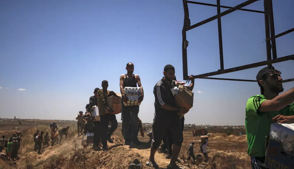 epa12143228 Palestinians carry aid supplies received from the US-backed Gaza Humanitarian Foundation through an area known as the Netzarim Corridor, central Gaza Strip, 29 May 2025. According to the UN half a million people, or one in five people in the Strip are facing starvation while the entire population of the Gaza Strip continues to face a critical risk of famine following 19 months of conflict, mass displacement and severe restrictions on humanitarian aid. EPA/HAITHAM IMAD