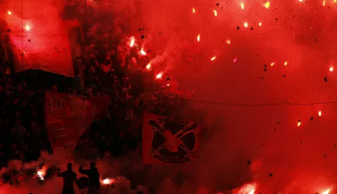 Olympiakos fans light flares ahead of the game with Panathinaikos at Piraeus' Karaiskaki Stadium on Saturday, Feb. 19, 2011. Heavy smoke from the flares delayed the start of the game, which was interrupted twice, again because of thick smoke, after each Olympiakos goal. Olympiakos won the derby 2-1. (AP Photo/Kostas Tsironis)