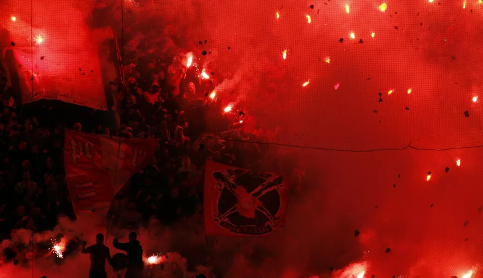 Olympiakos fans light flares ahead of the game with Panathinaikos at Piraeus' Karaiskaki Stadium on Saturday, Feb. 19, 2011. Heavy smoke from the flares delayed the start of the game, which was interrupted twice, again because of thick smoke, after each Olympiakos goal. Olympiakos won the derby 2-1. (AP Photo/Kostas Tsironis)