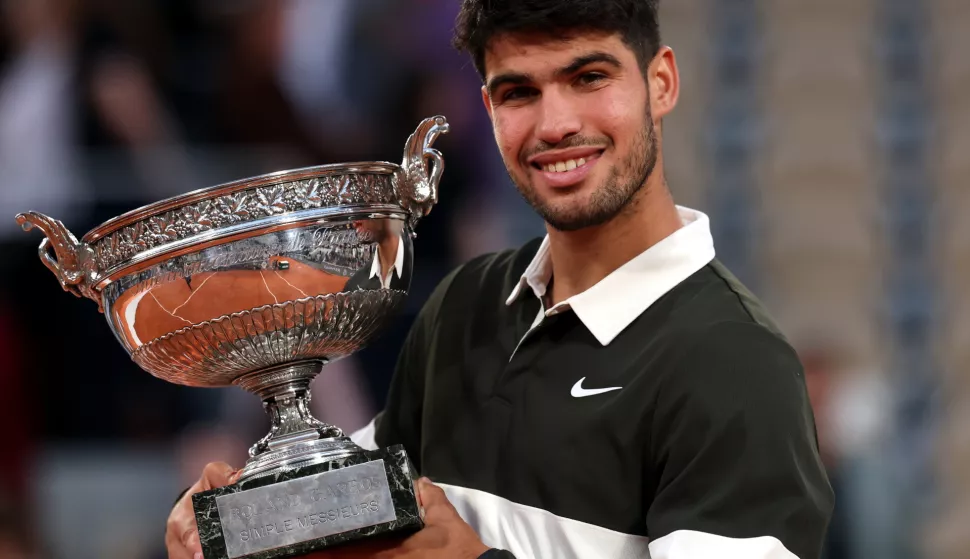 epa12164662 Carlos Alcaraz of Spain celebrates with the Coupe des Mousquetaires after winning his Men's final match against Jannik Sinner of Italy at the French Open Grand Slam tennis tournament at Roland Garros in Paris, France, 08 June 2025. EPA/MOHAMMED BADRA