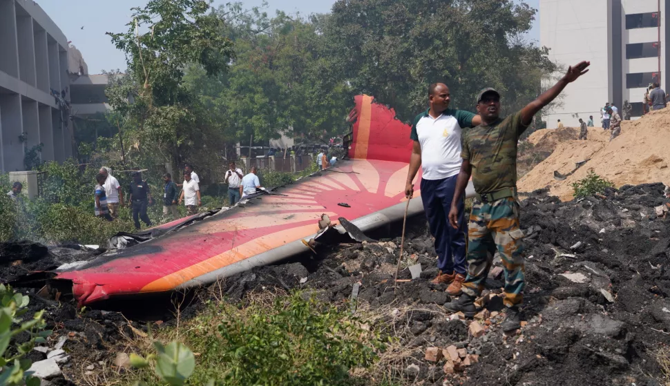 epaselect epa12171228 People stand near debris at the site of a plane crash near Sardar Vallabhbhai Patel International Airport in Ahmedabad, Gujarat, western India, 12 June 2025. Air India flight AI171, bound for London carrying 242 passengers and crew members on board a Boeing 787-8 aircraft, crashed minutes after take-off in the Meghaninagar area of Ahmedabad. EPA/SIDDHARAJ SOLANKI