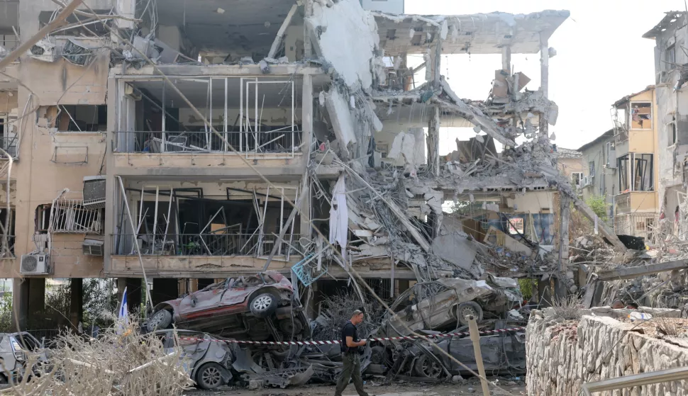 epa12174606 An Israeli police officer inspects a damaged residential building after a ballistic missile strike in Ramat Gan, near Tel Aviv, Israel, 14 June 2025. Israel's military said Iran launched dozens of missiles and drones toward Israel, with some intercepted. Magen David Adom (MDA), Israel's national emergency services, reported at least three killed and dozens of injured, including some in critical condition, in the retaliatory attacks. Israel launched strikes on Iran's nuclear and military facilities on 13 June, targeting top generals and scientists. EPA/ABIR SULTAN