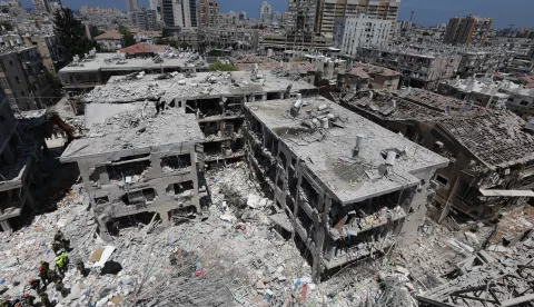 epa12176800 Members of Israel's Home Front Command search for missing people under the rubble of a partially collapsed residential building after Iranian ballistic missiles hit Bat Yam, central Israel, 15 June 2025. Iran launched a barrage of ballistic missiles at Israel overnight in retaliation for Israeli airstrikes on Iranian targets. Magen David Adom (MDA), Israel's national emergency services, reported at least six killed and dozens injured, including two in critical condition. EPA/ABIR SULTAN