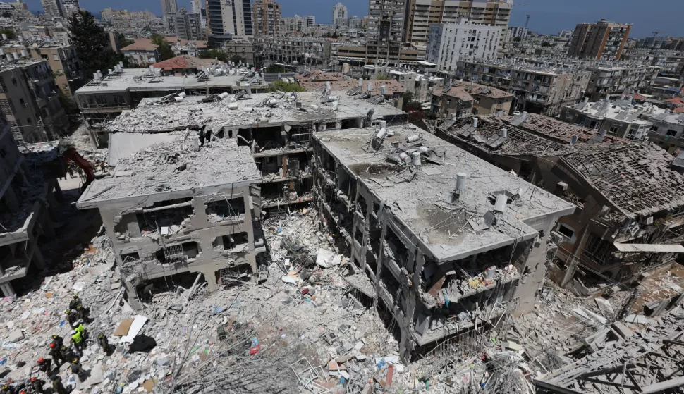 epa12176800 Members of Israel's Home Front Command search for missing people under the rubble of a partially collapsed residential building after Iranian ballistic missiles hit Bat Yam, central Israel, 15 June 2025. Iran launched a barrage of ballistic missiles at Israel overnight in retaliation for Israeli airstrikes on Iranian targets. Magen David Adom (MDA), Israel's national emergency services, reported at least six killed and dozens injured, including two in critical condition. EPA/ABIR SULTAN