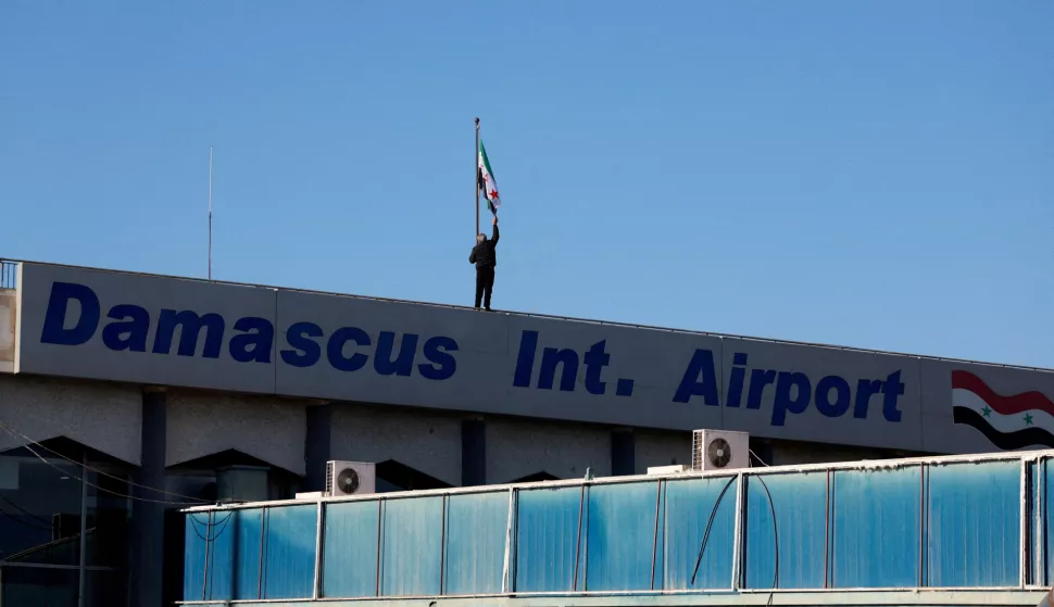 FILE PHOTO: A worker adjusts the flag adopted by the new Syrian rulers on the day the first domestic flight departs from Damascus International Airport to Aleppo International Airport during the re-opening of the airport after the ousting of Syria's Bashar al-Assad, in Damascus, Syria, December, 18 2024. REUTERS/Ammar Awad/File Photo Photo: AMMAR AWAD/REUTERS