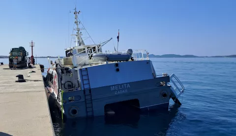 Zadar, 19.06.2025 - Nakon što se od trenutka havarije, u noći s 16. na 17. lipnja katamaran "Melita" nalazio u Zadarskom kanalu, sve aktivnosti bile su usmjerene na njegovo osiguranje i tegljenje na sigurno, odnosno do luke. Nakon stabilizacije i izravnavanja trupa, čime se osiguravalo da ne dođe do potonuća, katamaran "Melita" je 18. lipnja 2025. u 18.30 sati sigurno dotegljen i privezan u luci Gaženica.Tijekom jutra izvršeno je ispumpavanje tankova goriva te se, prema izjavi brodovlasnika, kreće s pripremom za tegljenje katamarana prema remontnom brodogradilišta "Iskra – Šibenik".foto HINA/ MMPI/ ds