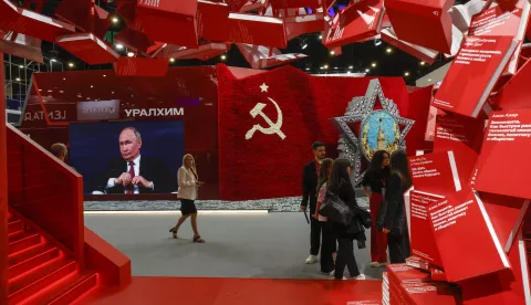 epa12187842 Participants pass a TV screen that shows Russian President Vladimir Putin during the 28th Saint Petersburg International Economic Forum (SPIEF) in St. Petersburg, Russia, 20 June 2025. The forum runs from 18 to 21 June 2025. EPA/ANATOLY MALTSEV