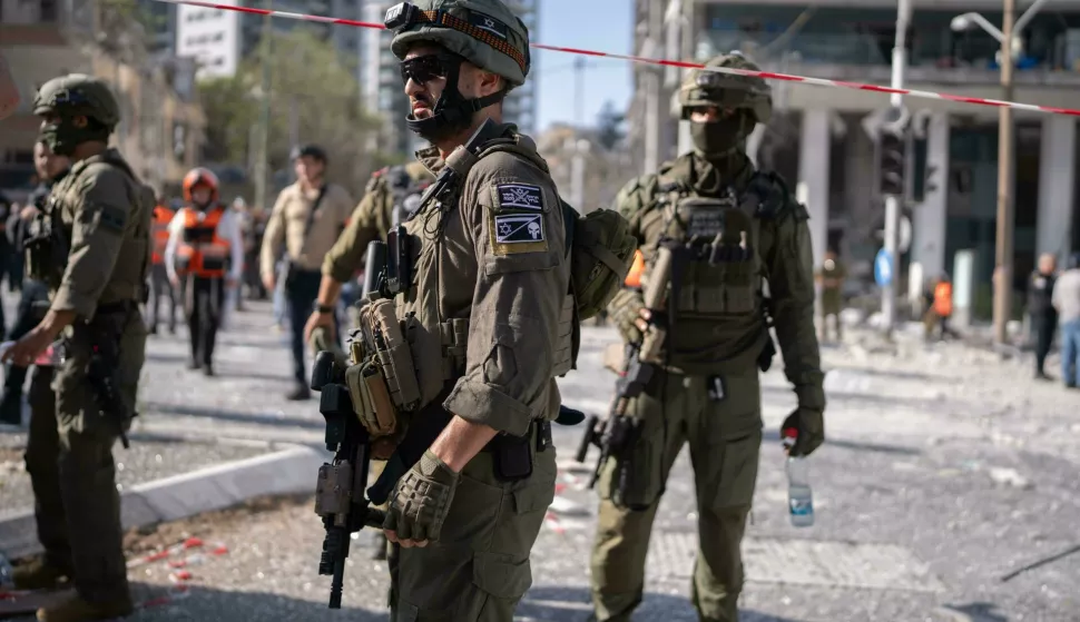 19 June 2025, Israel, Ramat Gan: Israeli soldiers stand as people are being evacuated after an Iranian missile on Ramat-Gan. Photo: Ilia Yefimovich/dpa Photo: Ilia Yefimovich/DPA