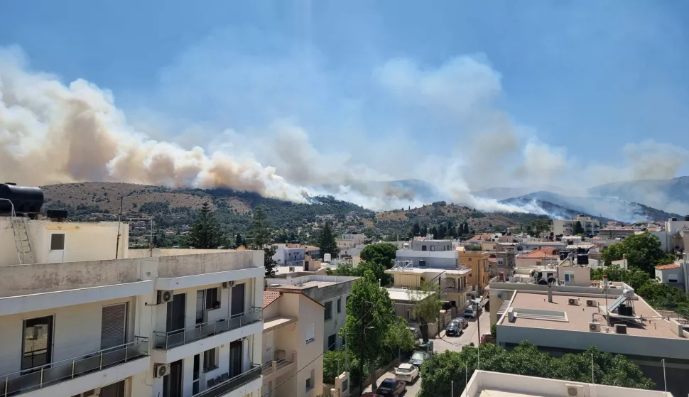 epa12190940 Thick smoke rises as a wildfire burns forested land next to residential areas on Chios Island, Greece, 22 June 2025. A fire that broke out over the main town of Chios island and is now out of control has led to messages for evacuation of several towns through the 112 emergency number service on 22 June. EPA/KOSTAS KOURGIAS