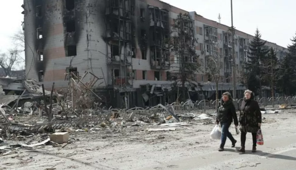 (220411) -- MARIUPOL, April 11, 2022 (Xinhua) -- Residents walk near a damaged building in Mariupol, April 10, 2022. (Photo by Victor/Xinhua) Photo: V Ictor/XINHUA