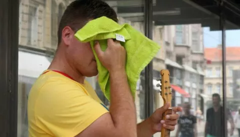 Osijek, 23.06.2017. - Ulicni tamburas cesto brise znoj s glave i ruku.Foto: Zeljko Sepic