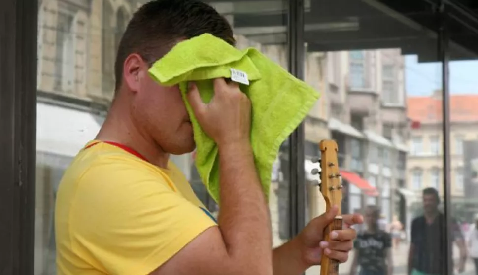 Osijek, 23.06.2017. - Ulicni tamburas cesto brise znoj s glave i ruku.Foto: Zeljko Sepic