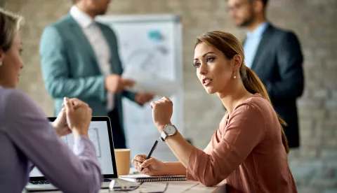 Young businesswoman talking to her female colleague during the meeting in the office.posao gospodarstvo ilustracija aktovka banka kredit pdv bdp gdp pregovori financiranje financije računovostvo freepik