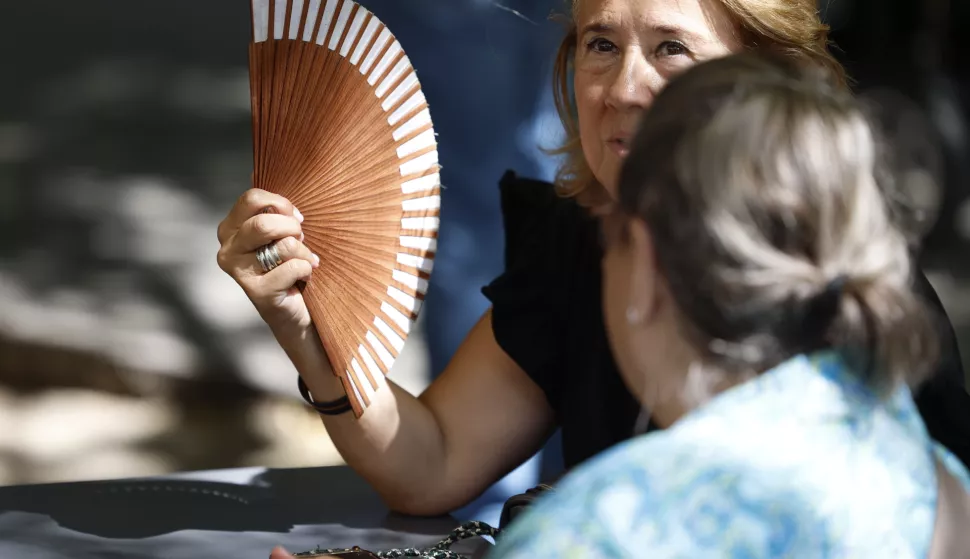 epa12183101 A woman uses a fan to cool down as high temperatures affect the Spanish capital Madrid, Spain, 18 June 2025. EPA/Mariscal