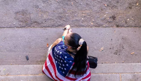 A woman draped in an American flag sits on the steps during an anti-ICE protest in downtown Los Angeles, California, on June 8, 2025. The protest erupted after a wave of federal immigration raids began on June 7, with National Guard troops deployed to the city despite objections from local officials. Demonstrators called for an end to deportations and the dismantling of ICE. Photo by Sahab Zaribaf/Middle East Images/ABACAPRESS.COM Photo: Middle East Images/ABACA/ABACA