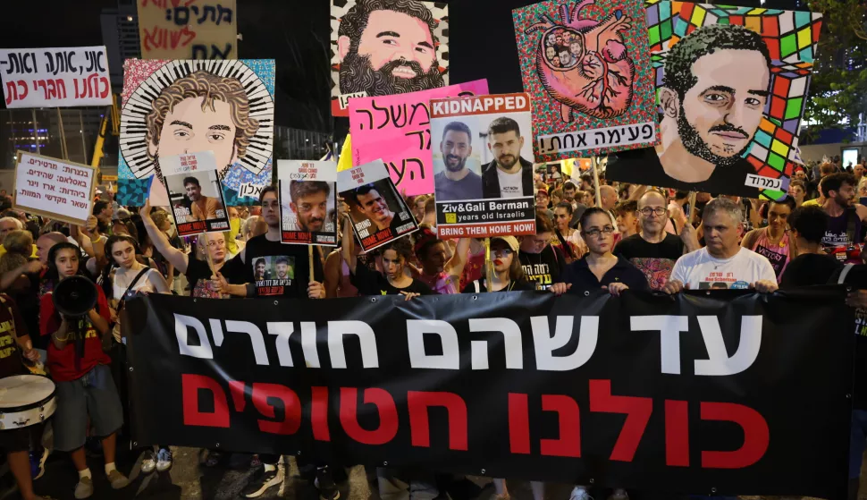 epa12234425 Families of Israeli hostages held by Hamas in Gaza hold a banner with 'until they will return we are all hostages' written in Hebrew during protest outside the Kirya military headquarters in Tel Aviv, Israel, 12 July 2025. According to the Israeli army (IDF) spokesperson, around 50 Israeli hostages remain in captivity in the Gaza Strip, including the bodies of at least 30 confirmed dead. EPA/ABIR SULTAN