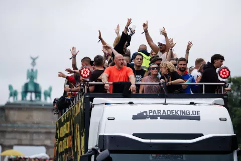 epa12234172 Participants on a float cheer in front of the Brandenburg Gate during the Rave the Planet parade under the slogan 'Our Future Is Now' in Berlin, Germany, 12 July 2025. The Rave The Planet parade is a cultural-political demonstration for peace, the protection and preservation of electronic music culture and the recognition of its cultural and social achievements, according to the organizers. EPA/CLEMENS BILAN