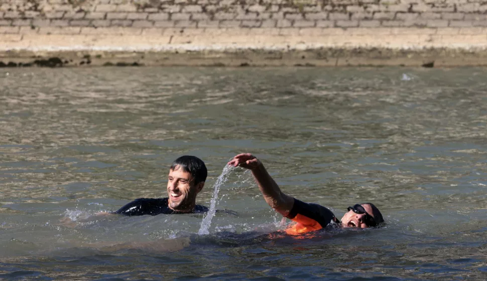 epa11483073 Paris Mayor Anne Hidalgo and President of the Paris 2024 Olympics and Paralympics Organising Committee Tony Estanguet (L) swim in the Seine to demonstrate that the river is clean enough to host the outdoor swimming events at Paris 2024 Olympic Games, in Paris, France, 17 July 2024. Despite an investment of 1.4 billion euros ($1.5 billion) to prevent sewage leaks into the waterway, the Seine has been causing suspense in the run-up to the opening of the Paris Games on 26 July, after repeatedly failing water quality tests. According to the Paris city hall on 12 July, the Seine has been clean enough for swimming for most of the past 12 days. EPA/JOEL SAGET/POOL MAXPPP OUT