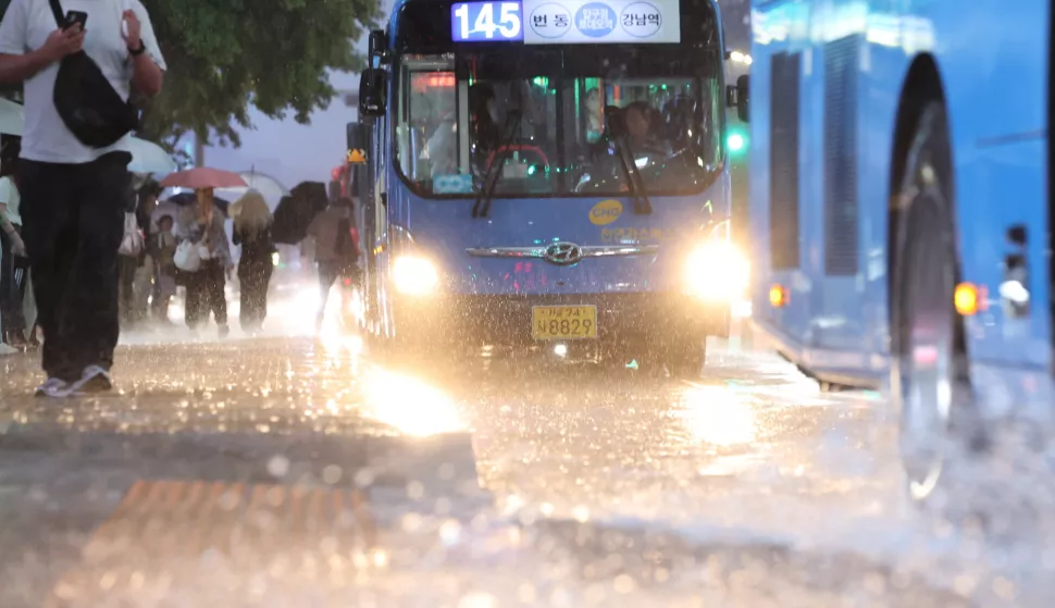 epa12241085 Buses drive through waterlogged roads near Gangnam Station in southern Seoul, South Korea, 16 July 2025, as a heavy rain advisory is issued. EPA/YONHAP SOUTH KOREA OUT