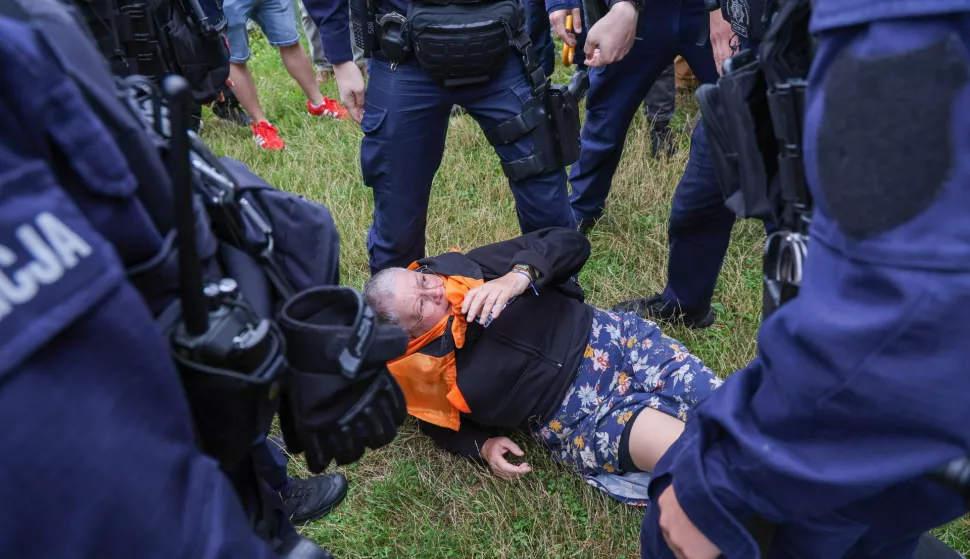 epa12247135 Police officers detain left-wing activist Katarzyna Augustynek during a far-right anti-immigration protest in Warsaw, Poland, 19 July 2025. Poland's far-right Confederation party organized 'Stop Immigration!' rallies in 80 cities and towns across the country to protest against the current government's migration policy. EPA/PAWEL SUPERNAK POLAND OUT