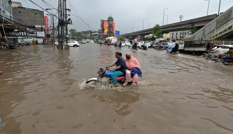 epa12229280 People ride on a motorbike during rainfall in Lahore, Pakistan, 10 July 2025. Recent monsoon rains have claimed more than 70 lives across Pakistan since 26 June, with Khyber Pakhtunkhwa being the most affected province, according to the National Disaster Management Authority. EPA/RAHAT DAR