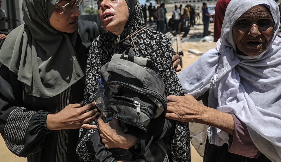 epa12250219 A Palestinian mother (C) hugs the bag of her son while mourning after he was shot dead at a food distribution point, at Al-Shifa Hospital in Gaza City, 20 July 2025. According to the Palestinian Ministry of Health in Gaza, at least 67 people were killed while trying to receive humanitarian aid in the Zikim area. EPA/MOHAMMED SABER