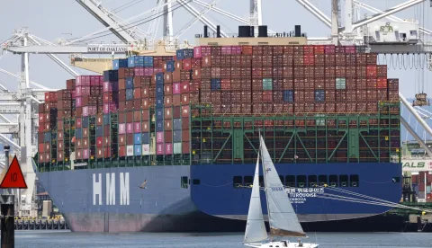 epaselect epa12238224 A sailboat sails past a container ship at the Port of Oakland in Oakland, California, USA, 14 July 2025. Recent tariff increases and trade policies, particularly those related to China, have significantly affected the port's operations and container volume. Shipping lines have been canceling voyages and skipping ports (known as 'blank sailings') in response to the uncertainty and reduced demand caused by tariffs, leading to a decline in container traffic at the Port of Oakland. Last week, US President Trump sent a letter to European Union leaders stating that he would impose a 30 percent tariff on goods imported from the EU beginning 01 August. Trump also threatened to impose 25 percent tariffs on Japan and South Korea, 30 percent on Mexico, and 35 percent on Canada. EPA/JOHN G. MABANGLO