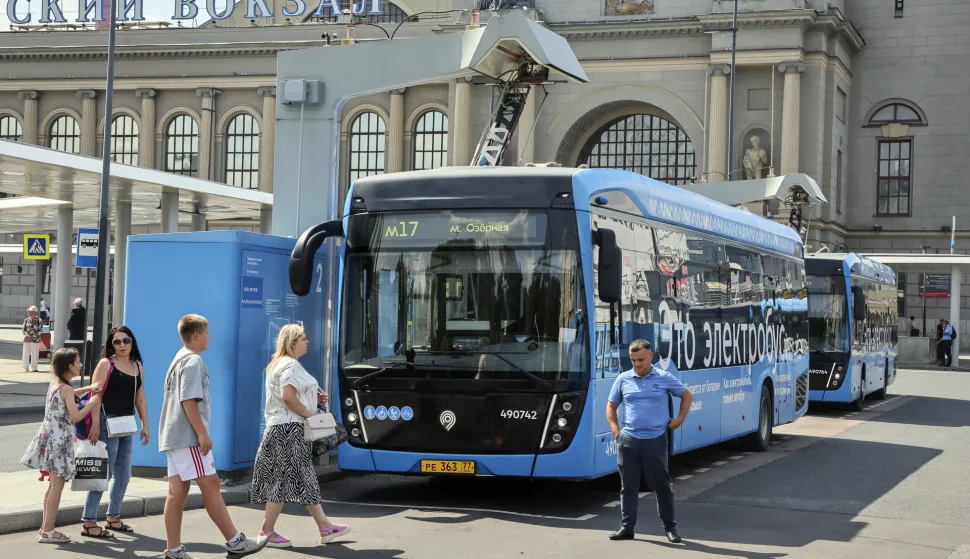 epa12261039 People walk past a charging station for electric buses, in Moscow, Russia, 25 July 2025. With over 2,300 electric buses currently operating on more than 200 routes in Moscow, the city's public transport aims to transition to an entirely electric fleet by 2035. EPA/YURI KOCHETKOV
