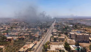 epa12245150 An aerial picture taken by drone shows smoke rising from the town of Al-Mazra'a as a result of burning houses following clashes between Bedouin tribes and local Druze factions, in the Suwayda countryside in southern Syria, on 18 July 2025. Several Bedouin tribes declared a general mobilization to fight against Druze factions after local Druze factions displaced Bedouin families and killed dozens of them. EPA/AHMAD FALLAHA