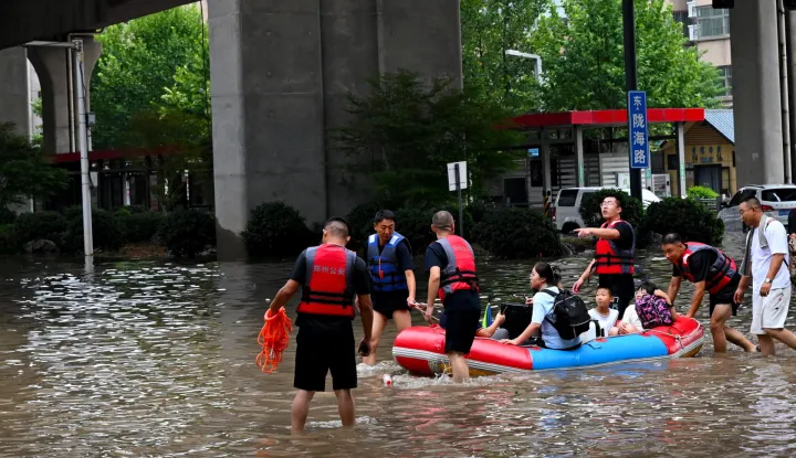 epa12288782 Staff members transfer citizens at an intersection in Zhengzhou, central China's Henan Province, 07 August 2025. Zhengzhou was hit by heavy rainfall on the day. EPA/XINHUA/HAO YUAN CHINA OUT/UK AND IRELAND OUT/  MANDATORY CREDIT EDITORIAL USE ONLY