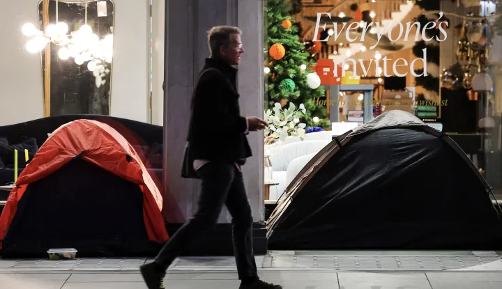 epa10960217 A pedestrian walks past tents used as shelter by homeless people on a sidewalk, in London, Britain, 06 November 2023. British Home Secretary Suella Braverman has announced that she plans to ban homeless people from living in tents, calling it 'lifestyle choice'. The British government is proposing new laws to restrict Britain's homeless from using tents. EPA/ANDY RAIN