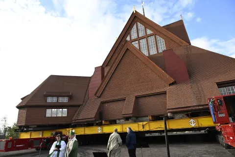 epa12309217 The Kiruna Church landmark is being moved on a specially designed trolley with 224 wheels at a speed of half a kilometer per hour in Kiruna, northern Sweden, 19 August 2025. The 40-meter-wide, 672,000-kilo wooden church has been placed on a wheeled trailer for its five-kilometre relocation to Kiruna's new town center on 19 and 20 August, due to the expansion of the iron ore mine. EPA/Fredrik Sandberg SWEDEN OUT