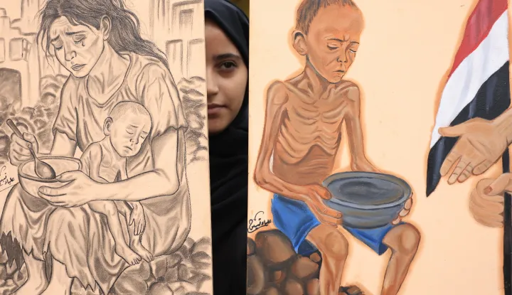 epa12312719 A protester holds anti-Gaza starvation paintings during a rally in solidarity with the Palestinian people, in Sana'a, Yemen, 20 August 2025. Hundreds of people rallied at Sana'a University to demand an end to the war in the Gaza Strip and the entry of all humanitarian aid into the enclave. EPA/YAHYA ARHAB