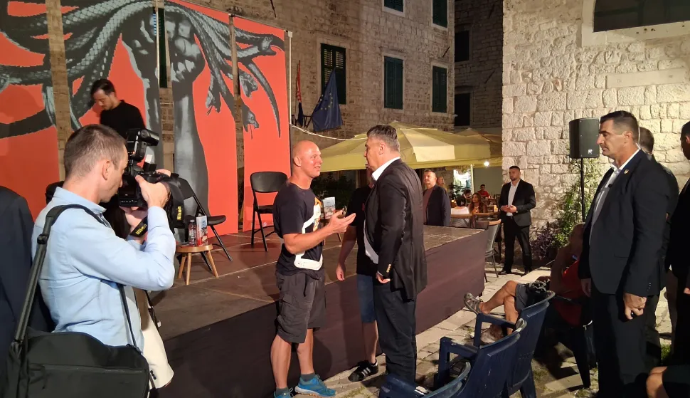 Šibenik, 04.09.2025. - Predsjednik RH Zoran Milanović u četvrtak navečer nenajavljeno je stigao na drugu večer Festivala alternative i ljevice u Šibeniku. Dolazak predsjednika Milanovića, uoči početka programa, publika FALIŠ-a na Trgu pape Ivana Pavla II. dočekala je s odobrenjem i ogromnim pljeskom. Nakon što je FALIŠ otvoren u srijedu navečer bez ijednog ekscesa na tvrđavi Barone, program se druge večeri preselio na Malu ložu, a među posjetiteljima u prvim redovima je predsjednik Milanović. Milanović je stigao na predstavljanje knjige "Sutjeska: bitka svih bitaka", autora Šimuna Cimermana, čiju je promociju uz moderatora Kruna Lokotara, slušao iz prvog reda. foto HINA/ Snježana KLARIĆ/ ml