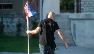 Benkovac, 06.09.2025. - U Benkovu je održan prosvjedno-performativni događaj pod nazivom "Nosi se kamen slobode" u organizaciji umjetnika i aktivista Juraja Arasa. Performans je izveden kao tiha i disciplinirana akcija. Nakon kratke obavijesti s pozornice o načinu sudjelovanja, sudionici su jedan po jedan uzeli kamen s obližnjeg parkirališta, donijeli ga do pozornice i odložili na hrpu ispod male zastave Republike Hrvatske.Na fotografiji: Juraj Aras, Foto HINA/Zvonko KUCELIN