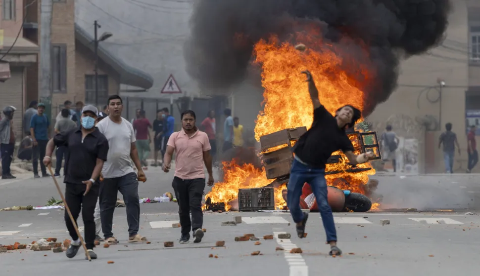 epa12363982 People stand near burning barricades during protests in Kathmandu, Nepal, 09 September 2025. At least 19 people were killed and dozens injured on 08 September during demonstrations against corruption and a government social media ban. EPA/NARENDRA SHRESTHA
