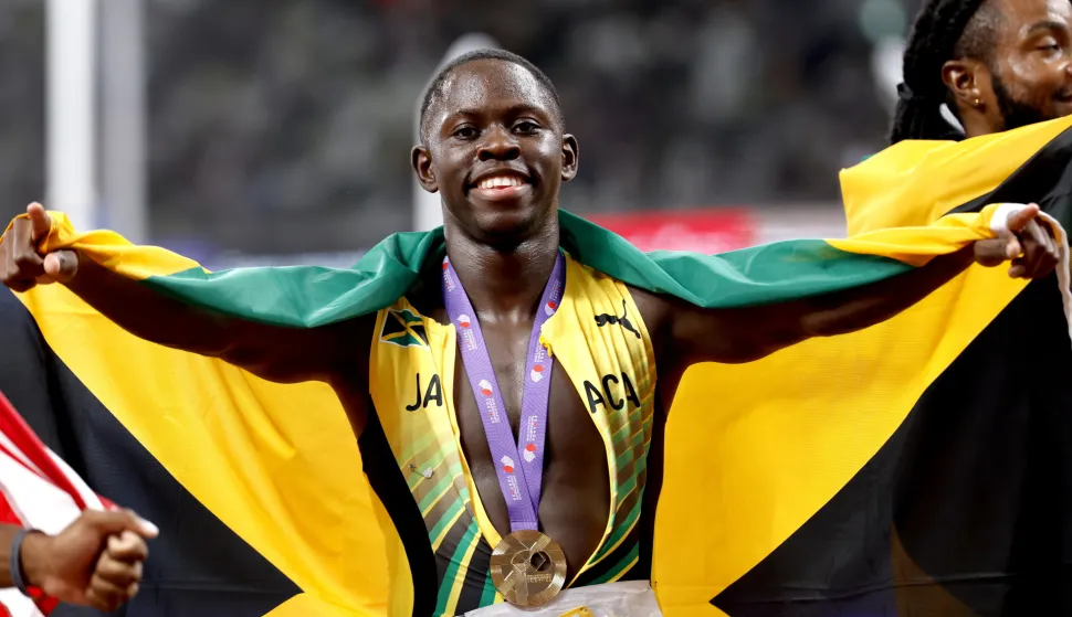 epa12376192 Oblique Seville of Jamaica celebrates after winning the Men's 100m final at the World Athletics Championships 2025 in Tokyo, Japan, 14 September 2025. EPA/FRANCK ROBICHON