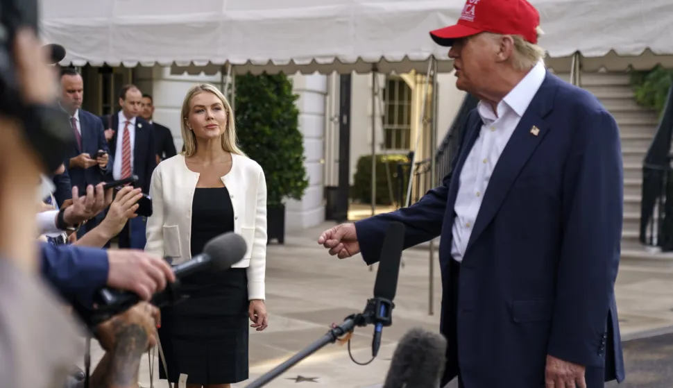 epa12208233 White House Press Secretary Karoline Leavitt (L) listens as US President Donald Trump speaks to the media as he leaves the White House in Washington, DC, USA, 01 July 2025. President Trump is due to visit a new immigration detention facility in the Everglades, Florida. EPA/WILL OLIVER/POOL