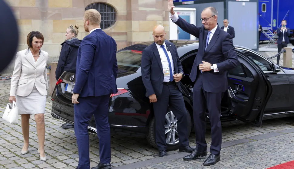 epa12426955 German Chancellor Friedrich Merz waves as he arrives (R) at an ecumenical service as part of celebrations for the Day of German Unity, in Saarbruecken, Germany, 03 October 2025. German Unity Day is marked annually on 03 October to commemorate the reunification of East and West Germany in 1990. EPA/CHRISTOPHER NEUNDORF