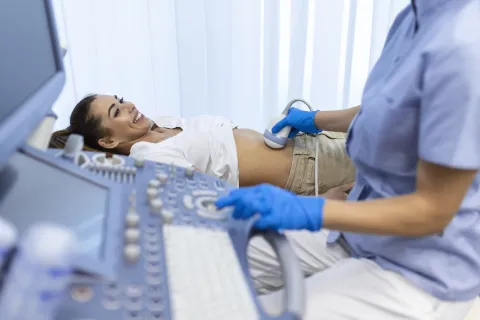 Ultrasound diagnostic of stomach on abdominal to woman in clinic, closeup view. Doctor runs ultrasound sensor over patient's girl tummy and looks at image on screen. Diagnosis of internal organs.ultrazvuk pregled doktor liječnik bolnica ilustracija freepik