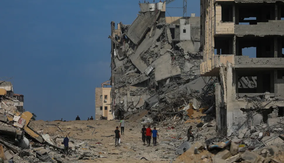 epa12444238 Palestinians walk along a street amid the rubble of destroyed buildings during a ceasefire between Israel and Hamas under the first phase of the Gaza peace plan, in Gaza City, Gaza Strip, 10 October 2025. Prime Minister Benjamin Netanyahu's office announced on 09 October that the Israeli government had approved the Gaza ceasefire and hostage release plan. EPA/MOHAMMED SABER